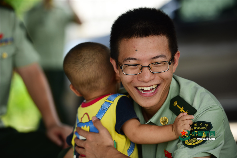 边防军人刘建高在辖区进行护鸟宣传,这是他和一名辖区的小孩玩耍.