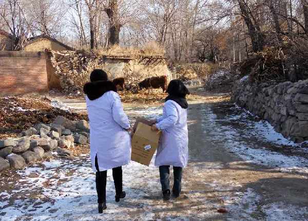 大雪没有阻挡他们的脚步，医生为村民搬运药品、医疗物资。