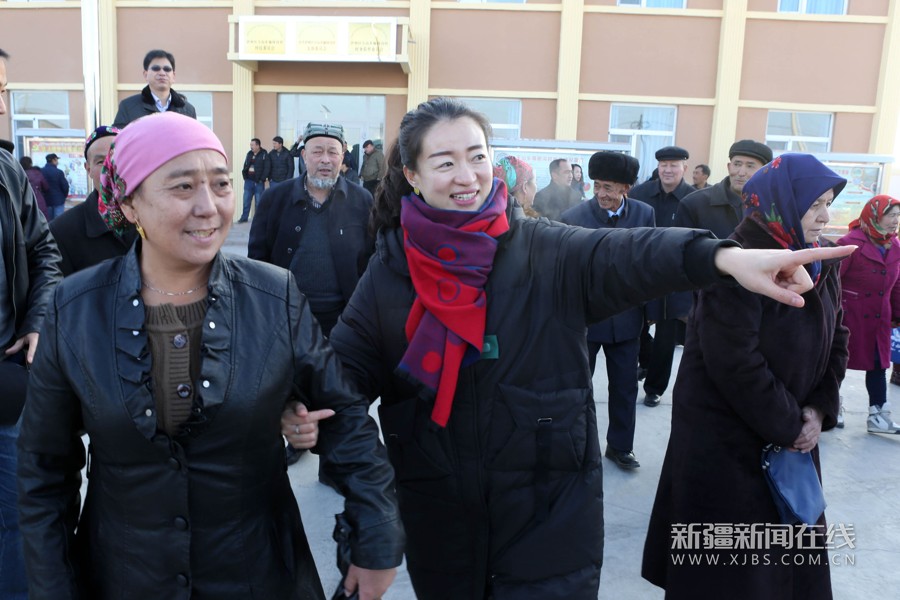 1月7日,哈密市发改委干部汤天慧(中)在伊州区天山乡榆树沟村接上亲戚