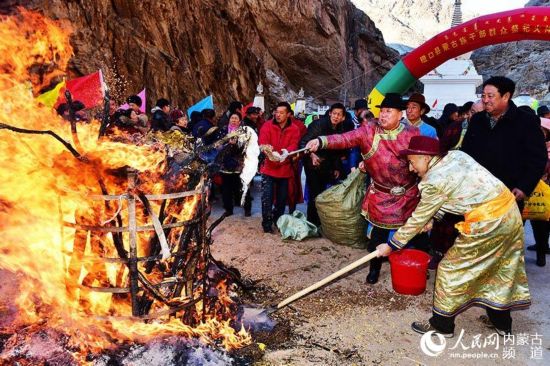 巴彥淖爾市磴口縣，蒙古族干部群眾把祭品灑向篝火。邢皓 攝