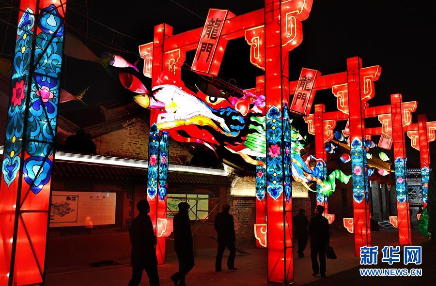 1月20日,在韩城市古城区,市民参观即将开展的国际灯展中的龙门作品