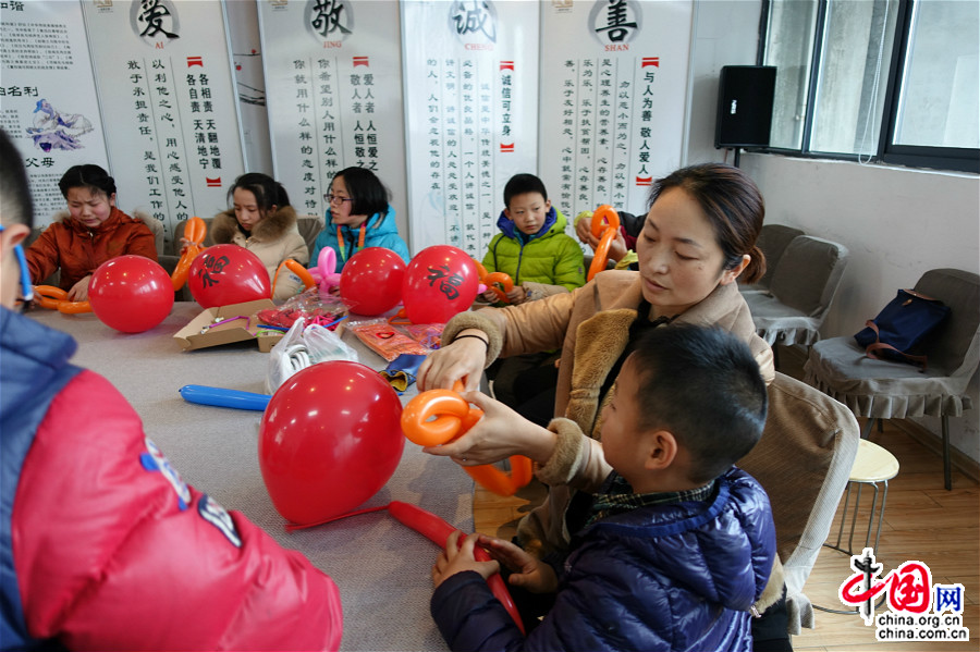 1月23日，活动中，孩子父母齐动手，一起向社工学习制作气球灯笼，红红火火迎新年。（中国网王文晔摄）