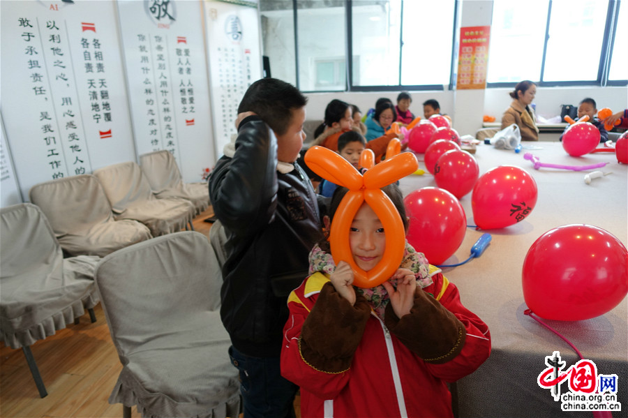 1月23日，参加活动的小姑娘拿着自己学习制作的气球灯笼很开心。（中国网王文晔摄）