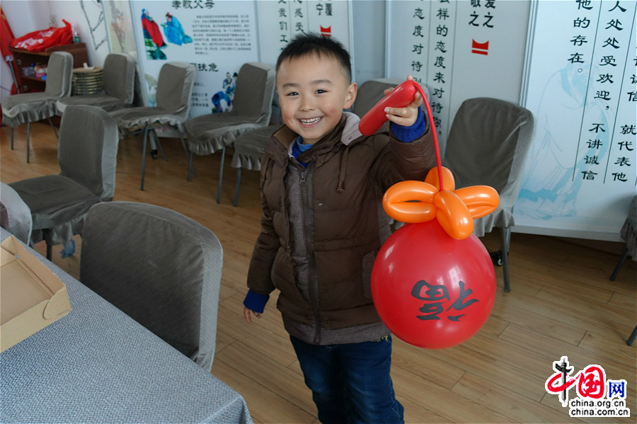 1月23日，小朋友拿着自己学习制作的气球灯笼很开心。（中国网王文晔摄）
