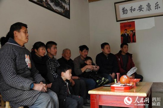 村民胡宗鹏一家人围坐在客厅看电视。（张枥 摄）