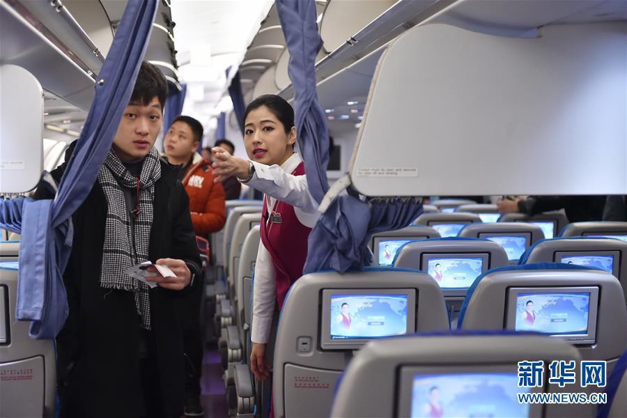 1月24日,秦思为登机的旅客做指引.