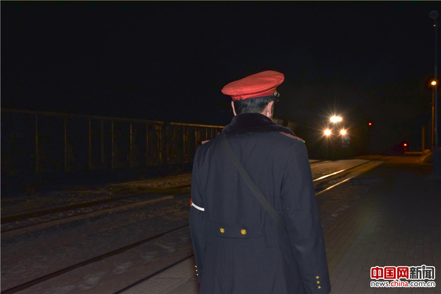 列车即将接近或通过本站时，值班员在夜幕中到室外接车。