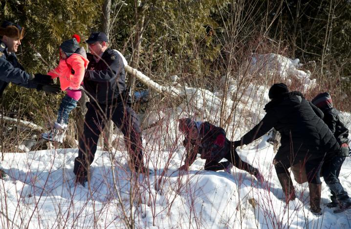 难民儿童被加拿大骑警抱过边境 美国警察在咆哮