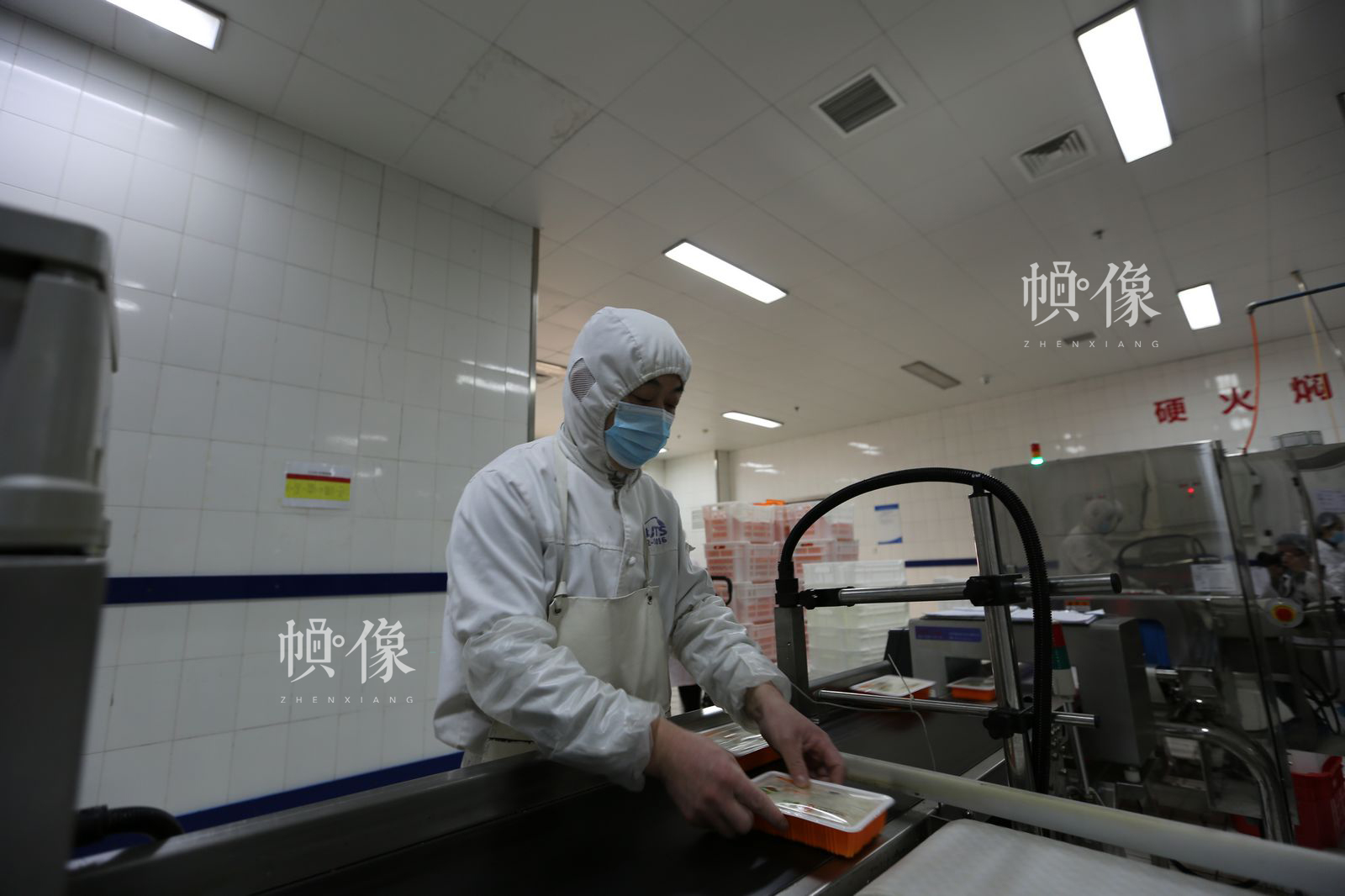 工人将成型的米饭放入检测流水线做相关检测。中国网记者 吴闻达 摄