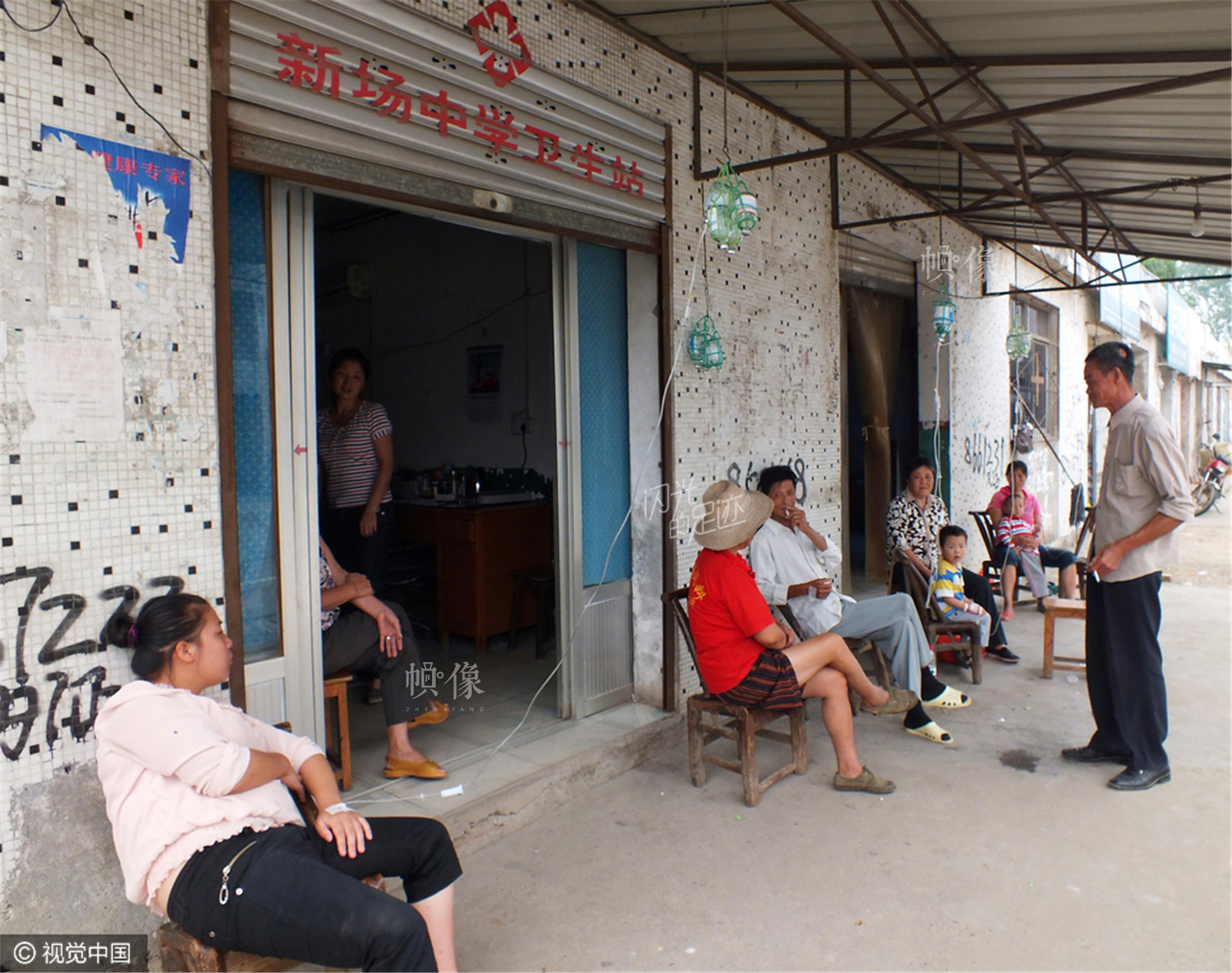 2011年9月5日，湖北宜昌夷陵區鴉鵲嶺鎮新場村，幾位農民患者在簡陋的新場中學衛生站輸液。（視覺中國）