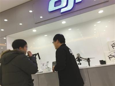 飞态创新店工作人员（右）向记者证实，该店销售的部分无人机经改装可在北京禁飞区内飞行。