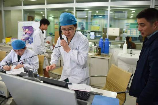 安徽医科大学第一附属医院产科的张晓慧医生（前中）为一位急需入院的产妇联系加床（2016年3月15日摄）。新华社记者 郭晨 摄