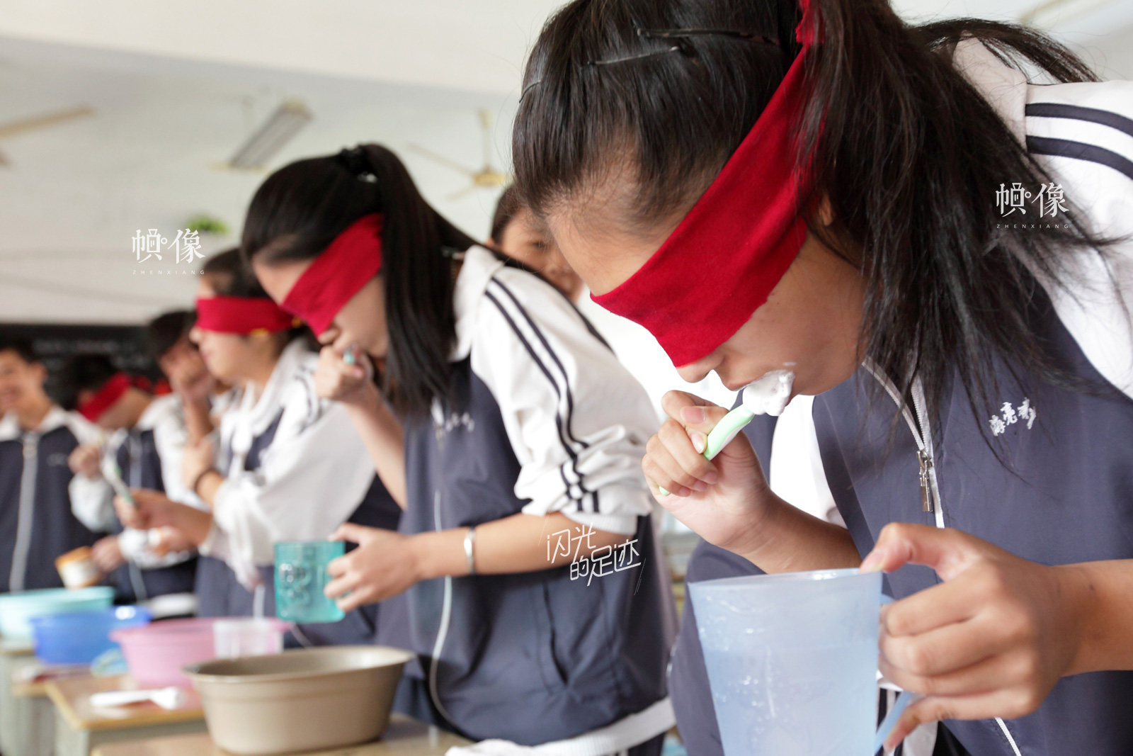 2014年10月14日，浙江省诸暨市海亮高中的学生通过蒙眼洗脸刷牙、倒水喝茶、穿衣系鞋带、走楼梯等很普通的日常生活，体验盲人朋友的艰辛，教育学生懂得关爱盲人、关心残疾人。（视觉中国）