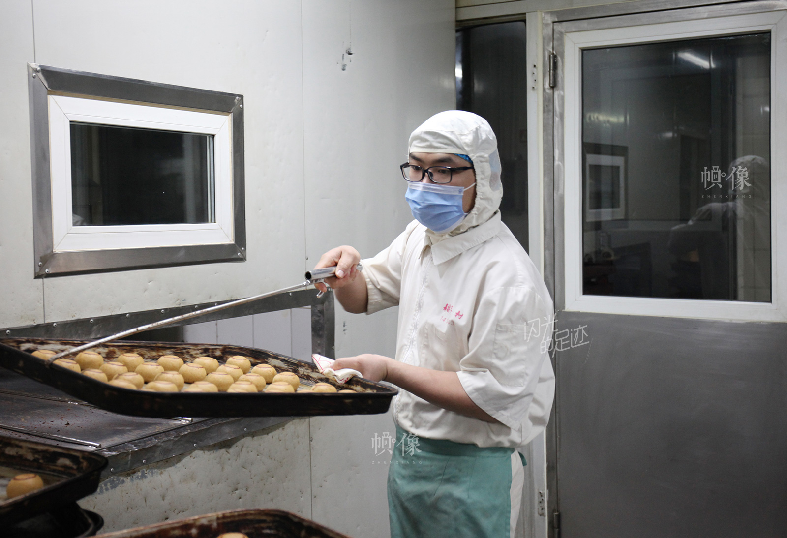 2017年3月2日,北京稻香村生产加工车间,工人正在处理刚出炉的糕点