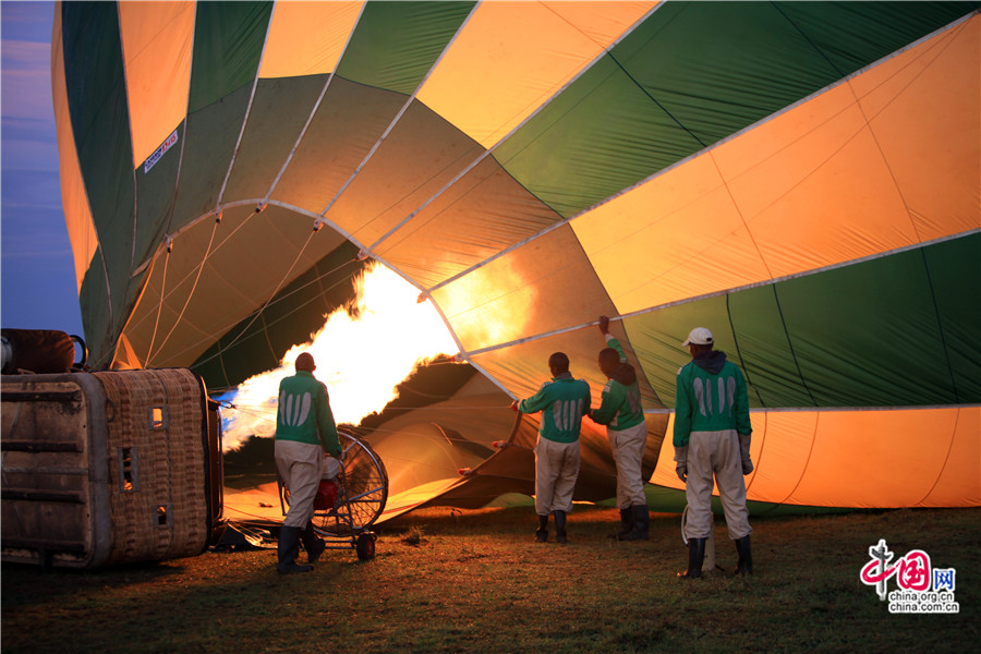 工作人员正在熟练地对热气球打火充气