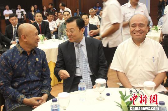 图为中国驻印尼大使谢锋(中)与印尼总统府幕僚长德登(左)、印尼国企部专员(右)出席签字仪式时亲切交谈。 林永传 摄