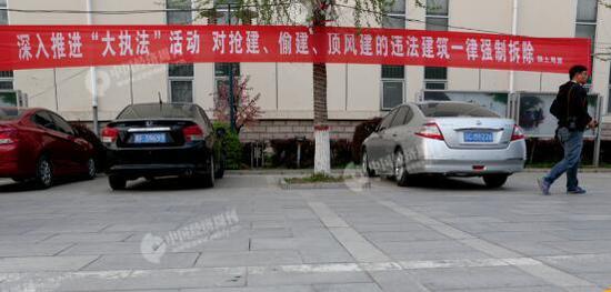 雄县人民政府附近一栋建筑外悬挂的打击违建的宣传语。