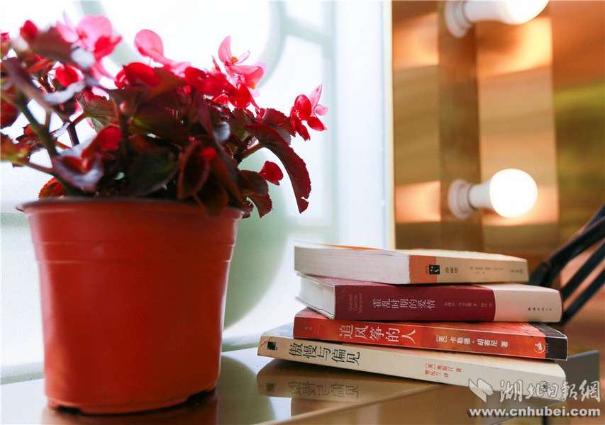 朗读亭空间内装着数个暖黄色灯光的小圆灯，置物架上还温馨地放着几盆小植物及部分书本。