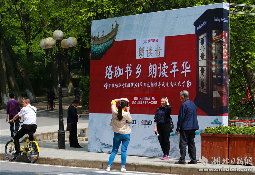 图为学子们在《朗读者》线下活动展板前牌照留念。