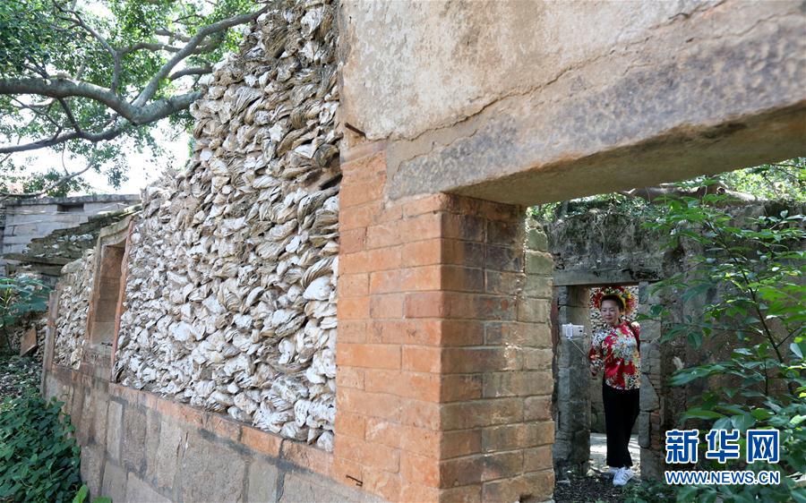 4月24日,在福建省泉州市丰泽区蟳埔村,一名游客参观一处蚝壳厝.