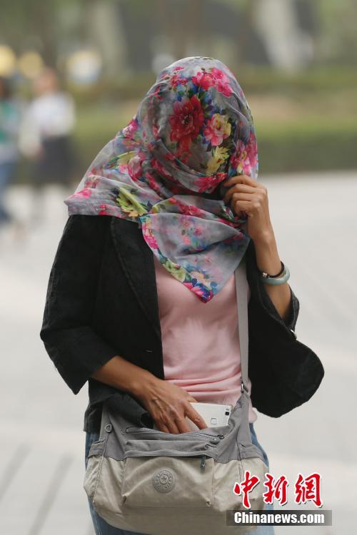 5月4日,北京城区遭沙尘笼罩,民众头戴纱巾出行 中新社记者韩海丹 摄