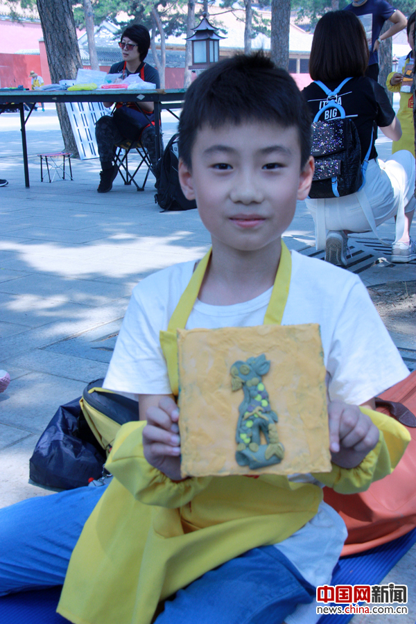  5月18日，在故宫博物院，来自北京市板厂小学的三年级学生黄韦豪开心地展示自己的软陶作品“脊兽”。 摄影 中国网 苏向东