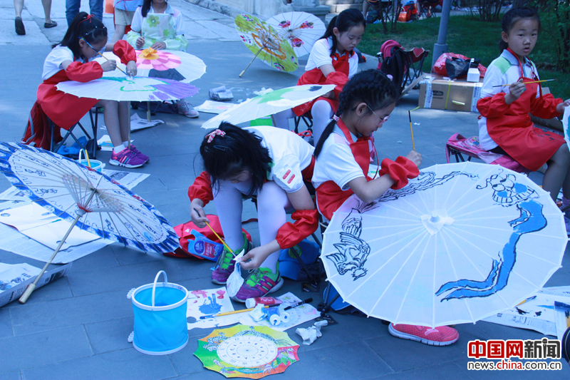  5月18日，在故宫武英门外，北京市海淀区双榆树第一小学的40名学生在进行“故宫元素彩绘伞”活动。