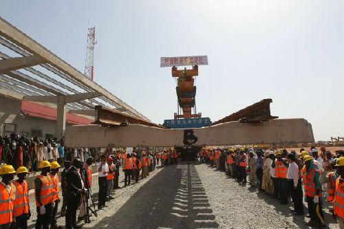 2014年12月1日，在尼日利亚阿布贾，工人铺设铁路最后一节轨排。当日，中国铁建承建的尼日利亚铁路现代化项目第一标段——首都阿布贾至卡杜纳铁路（阿卡项目）宣告全线铺通。首条中国标准尼日利亚现代化铁路通车在即。（新华社）