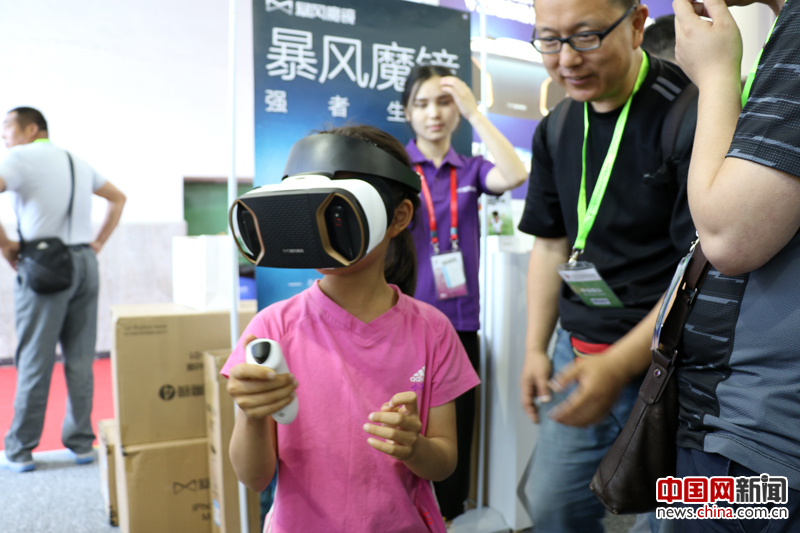 2016年5月21日，在第十九届北京科博会上，一个小女孩从爸爸手里抢过VR魔镜说，“我也看看魔镜里究竟有什么？” 摄影 苏向东