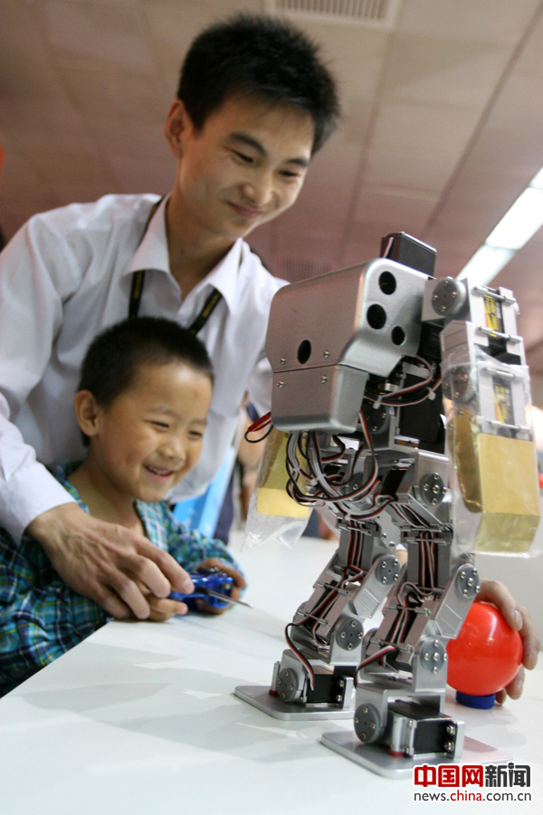 2007年，一名男孩在工作人員的幫助下“指揮”機器人。 攝影 陳曉根
