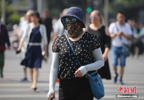 资料图：5月17日，北京街头的民众防晒出行。当日北京发布了今年首个高温黄色预警。中新社记者 杨可佳 摄