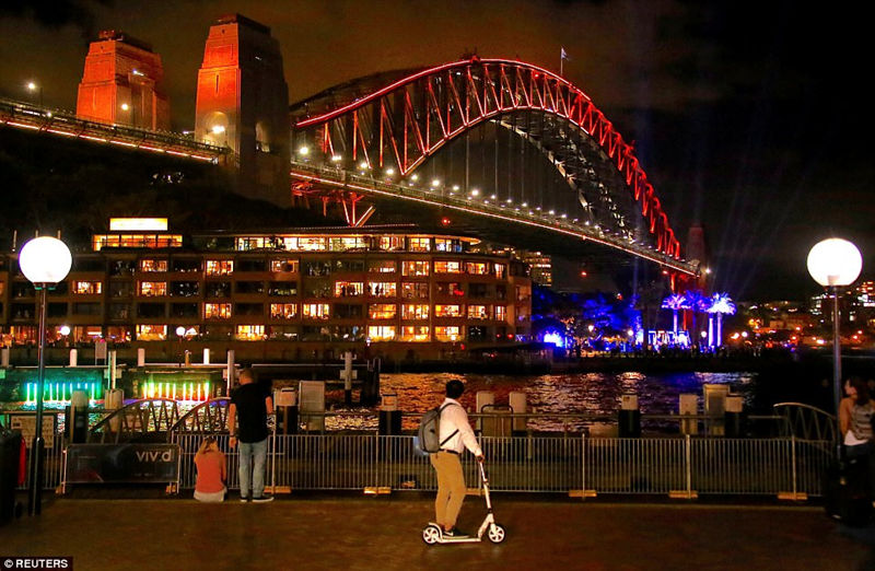 悉尼现在正值晚秋，在悉尼海港大桥上，橙色的光增添了一抹温暖。