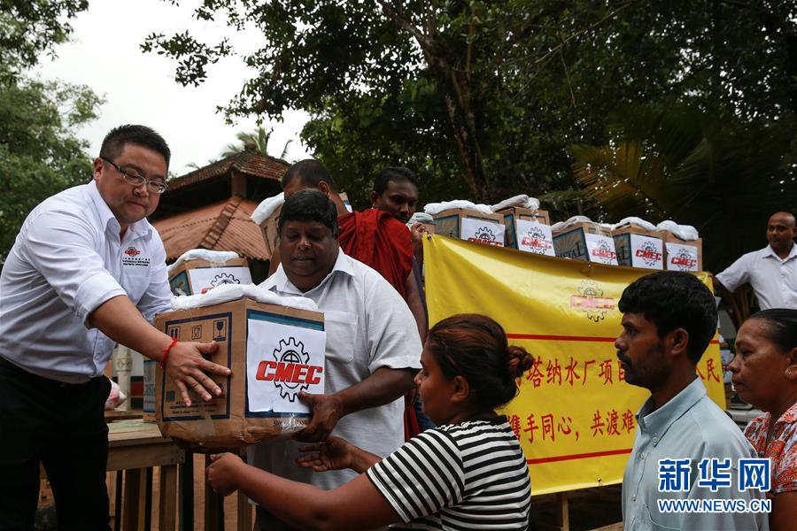 在斯里兰卡科伦坡附近的亚巴拉鲁瓦村，中国机械设备工程股份公司阿塔纳水厂项目组工作人员（左一）为灾民分发赈灾物资