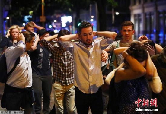 当地时间6月3日，英国伦敦相继发生三起袭击事件，导致至少一人死亡，多人受伤。警方确认，前两起事件为恐怖袭击，第三起袭击事件与前两起恐袭无关。图为英国伦敦桥恐袭发生后，桥上及周边区域的民众举手排队接受警方的检查。