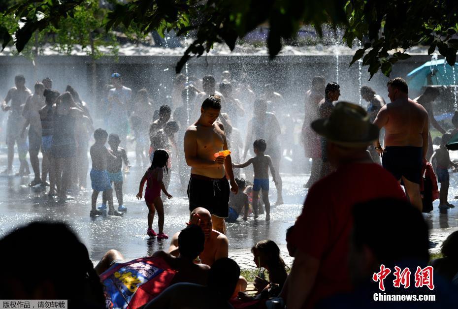 在马德里，很多当地居民和游客都来到公园的树荫下和喷泉边乘凉。