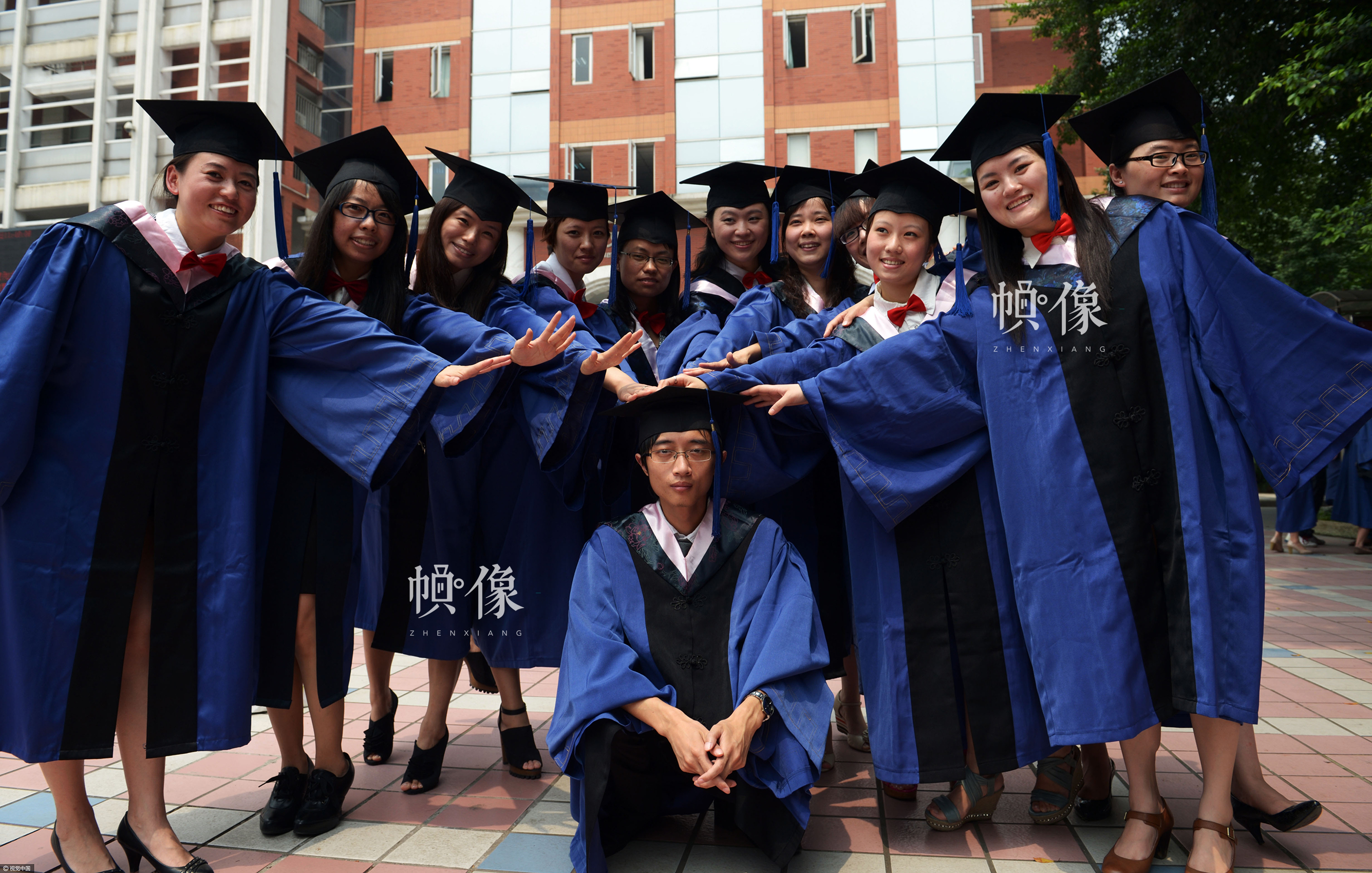 2012年6月20日，重庆，大学毕业生拍毕业照。川外学生向来是男少女多，被班里同学誉为国宝的男同学陈首为，在照相时也被女同学欺负。视觉中国供图