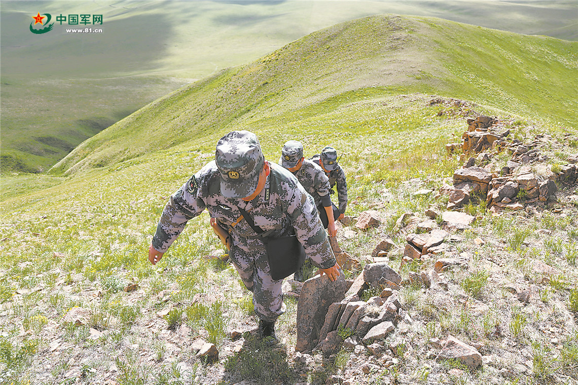 巡逻官兵攀行在陡峭的山脊上。