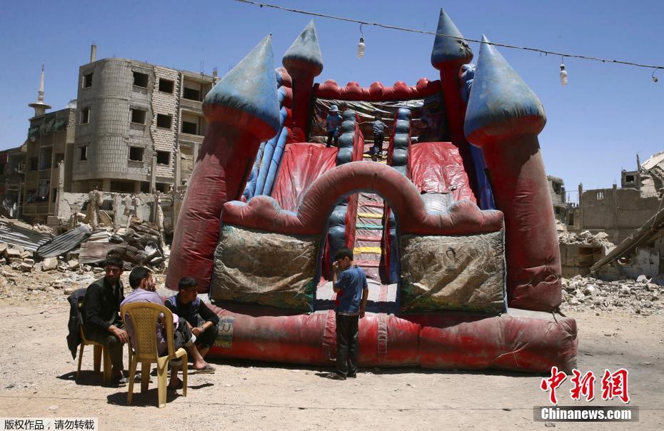 叙利亚反对派控制区杜马，儿童在充气城堡里玩耍庆祝开斋节。