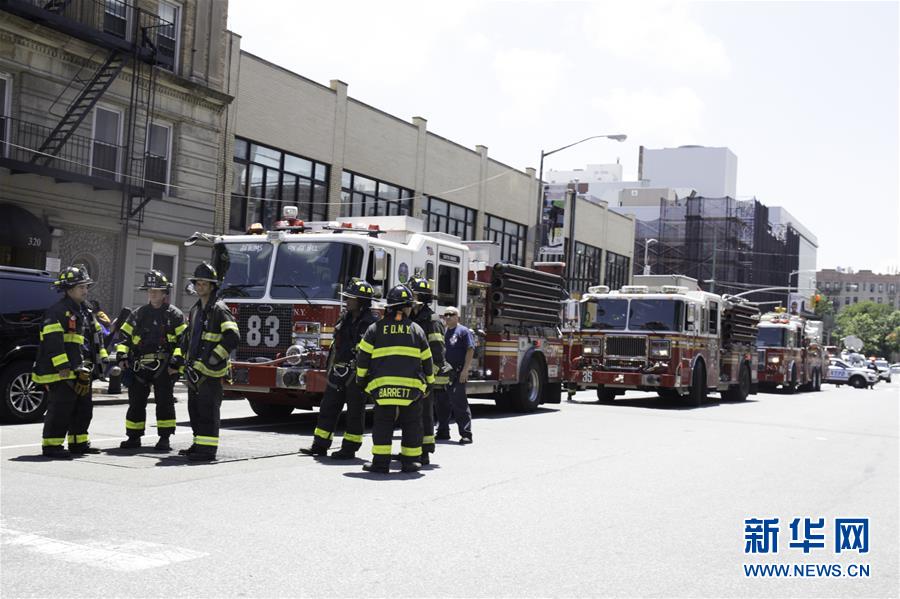 　6月27日，在美国纽约，救援人员聚集在发生脱轨事故的地铁站附近。