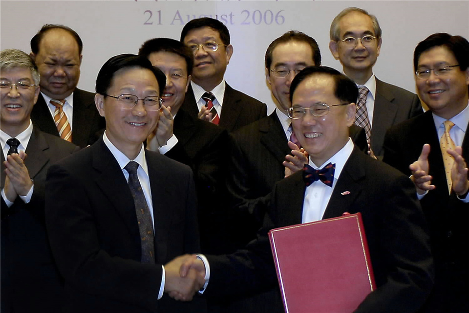 国家税务总局局长谢旭人（前左）与香港特区行政长官曾荫权（前右）在签字后握手