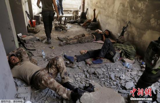 图为反恐服务处的成员们在位于摩苏尔古城的伊拉克军队重新夺回后，在大努里清真寺遗址旁的位置休息。