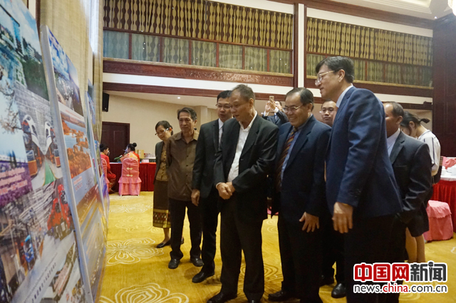 吉林省新闻代表团团长张树斌(右一)陪同老挝朋友观看“我是'吉林'”图片展。