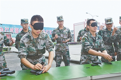 西南交通大学电工理论与新技术专业博士何庆勇（右二）创造了所在部队92式手枪分解结合17秒的训练纪录。