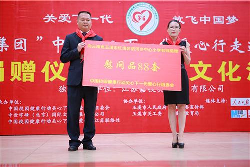 中国校园健康行动关心下一代爱心行组委会秘书长贺杨向玉溪市红塔区洛河乡中心小学老师捐赠慰问品