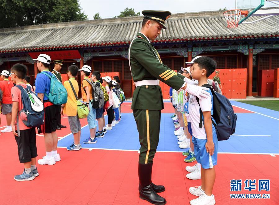 7月11日,天安门国旗护卫队战士在纠正香港小学生的站姿.