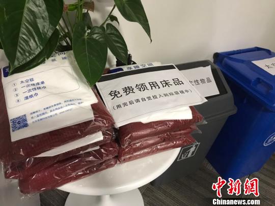 舱门右侧摆放着免费领用的床品，包括太空毯、一次性床单、一次性枕巾和湿纸巾。　王子涛 摄