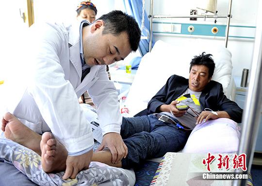 资料图：北京天坛医院的外科专家为脚部跟骨粉碎性骨折的患者检查。 中新社发 李林摄