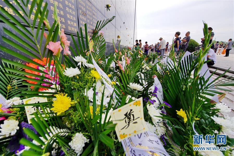 7月28日,唐山市民在地震紀念牆前祭奠遇難的親人.