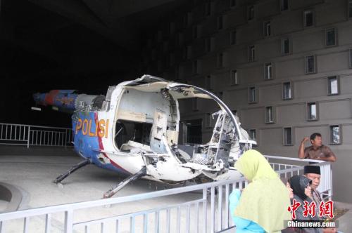 资料图：2014年12月，印尼亚齐举办地震海啸灾难10周年纪念活动。观众在印尼亚齐市中心的海啸博物馆内参观海啸遗骸、图片展。