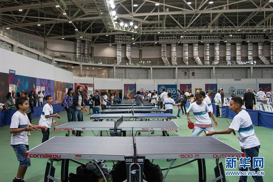 8月5日，当地孩子们在里约奥运公园内的三号里约人场馆内体验乒乓球。
